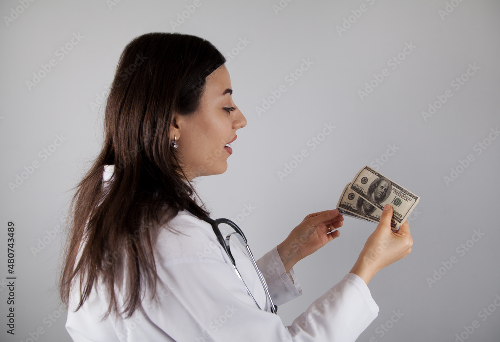 Woman doctor holding a dollar. Corruption or bribe concept. Woman doctor holding a dollar. Corruption or bribe concept.
