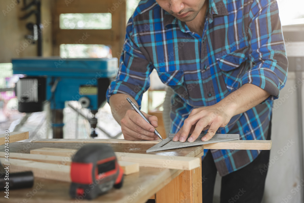 Hands of person doing diy project at home. Man measuring wood to doing cabinet craftworks as a hobby. Hands of person doing diy project at home. Man measuring wood to doing cabinet craftworks as a hobby.