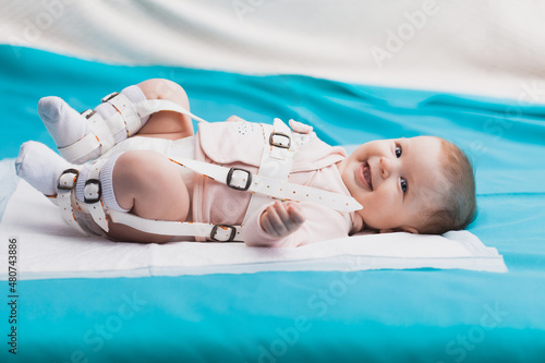 A baby wearing a harness that corrects hip dysplasia photo
