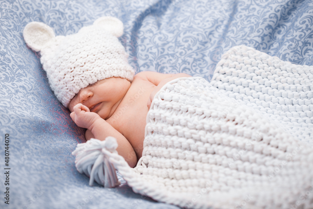 Cute newborn baby girl in a knitted hat on the white backdround Cute newborn baby girl in a knitted hat on the white backdround