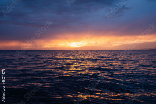 Calm golden sunset on open water while sailing the atlantic ocean