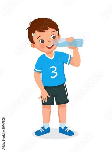 Cute little boy drinking fresh water from a bottle feeling thirsty after doing sport exercise