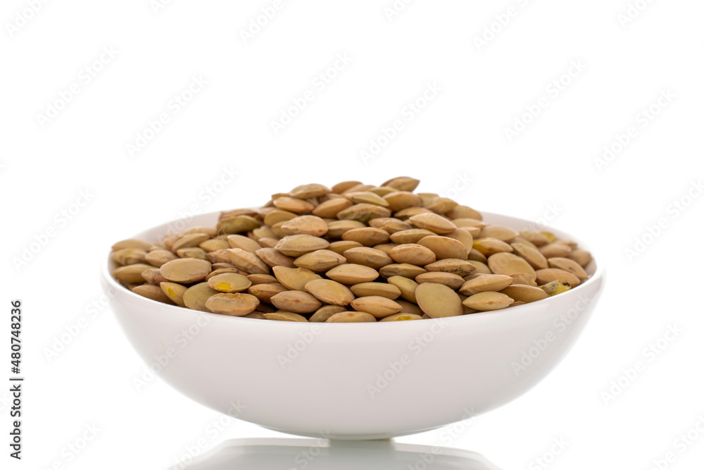 Raw organic green lentils in white ceramic saucer , macro, isolated on white. Raw organic green lentils in white ceramic saucer , macro, isolated on white.
