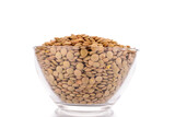 Raw organic green lentils in a glass bowl, macro, isolated on white.