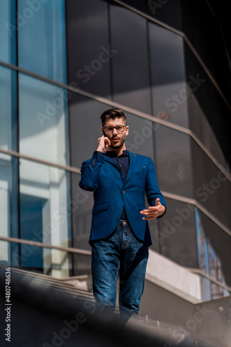 Business man walking while talking on mobile phone on his way to work