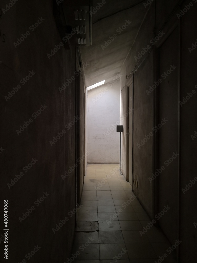 Old building with creepy corridor and a light at the enf

