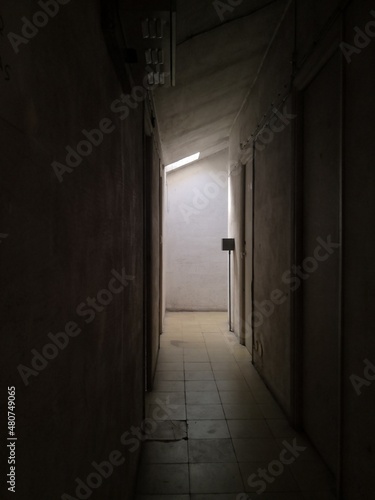Old building with creepy corridor and a light at the enf 