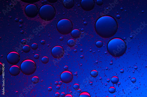 abstract background. drops of oil on water, blue and red. macro