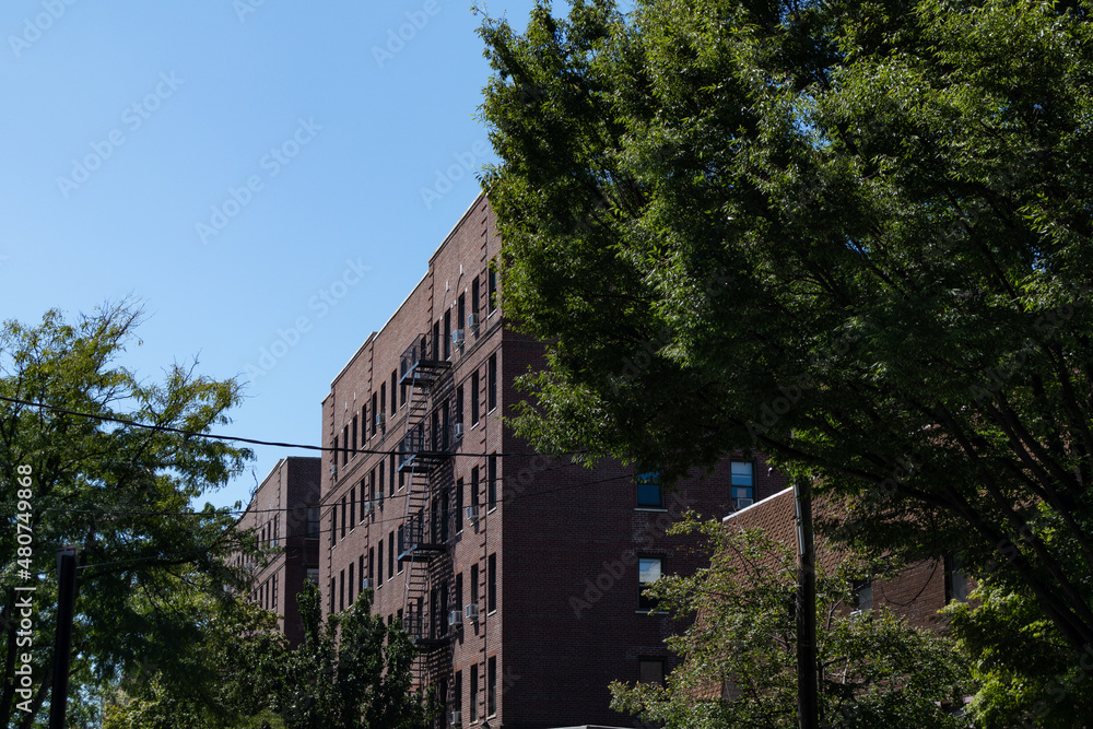 Row of Generic Old Brick Apartment Buildings with Fire Escapes in Astoria Queens of New York City Row of Generic Old Brick Apartment Buildings with Fire Escapes in Astoria Queens of New York City