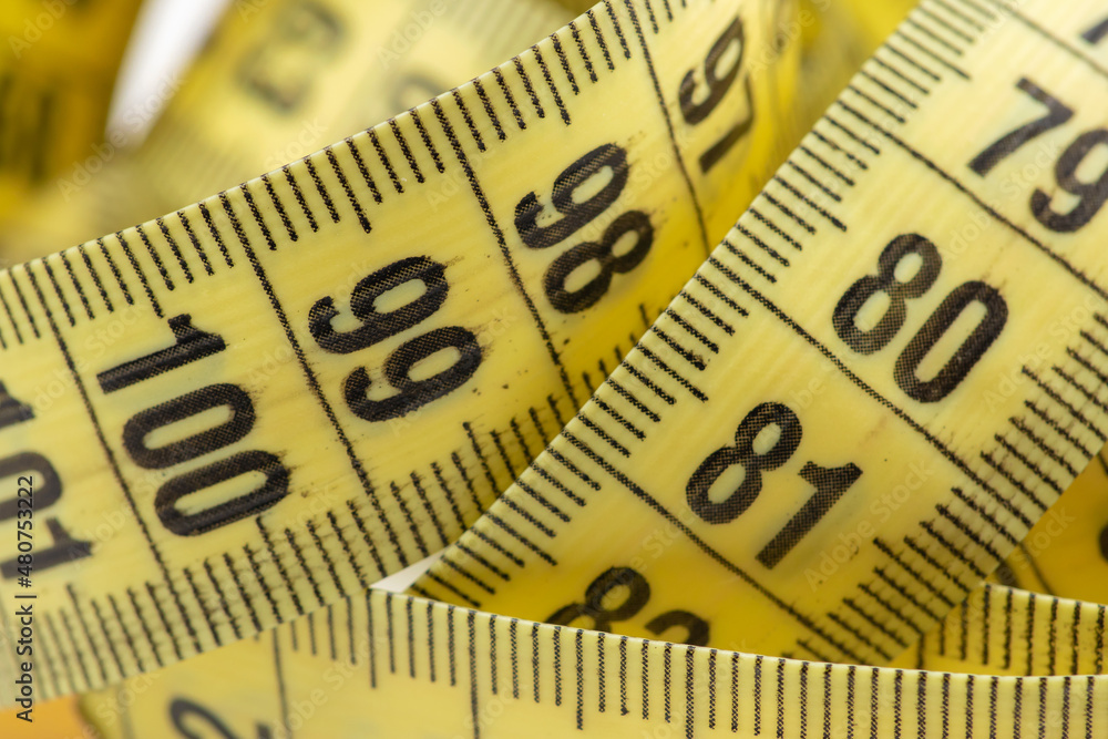 Yellow curved measuring tape close up Yellow curved measuring tape close up