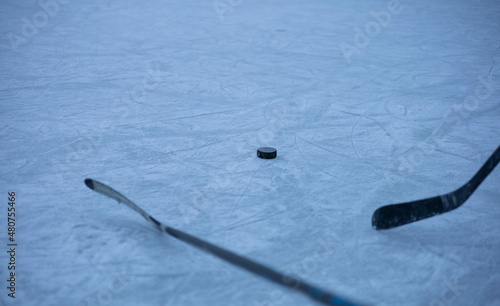 Eishockey Puck mit zwei Schläger am Eis