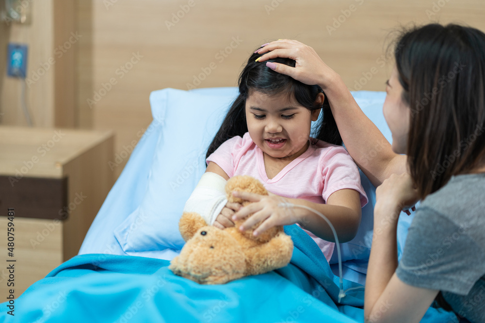 asian girl with a broken arm wearing a cast on the hospital bed with her mother asian girl with a broken arm wearing a cast on the hospital bed with her mother