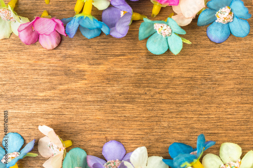 Happy easter concept, colorful spring holiday flower decoration border, old rustic wood background. Flat lay design, top view with copy space photo