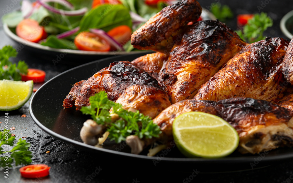 Roast Chicken Tabaka with salad, corn and lime on black plate. Roast Chicken Tabaka with salad, corn and lime on black plate.