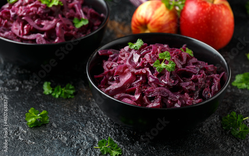 Fototapeta Braised Red Cabbage with apples and redcurrant in black bowl