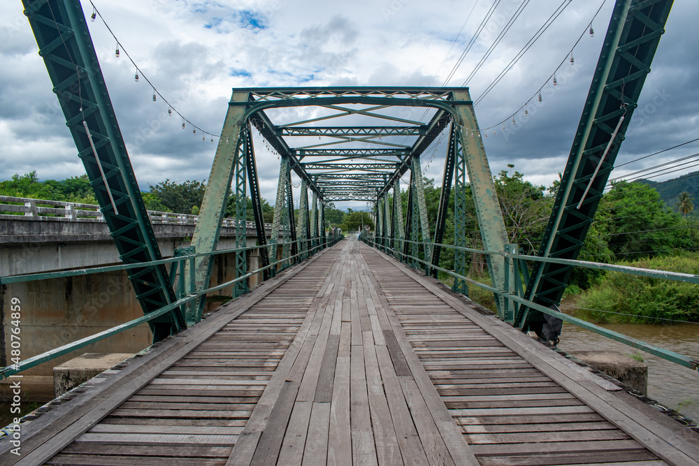Fototapeta premium Green steel bridge with wooden plank walkway 