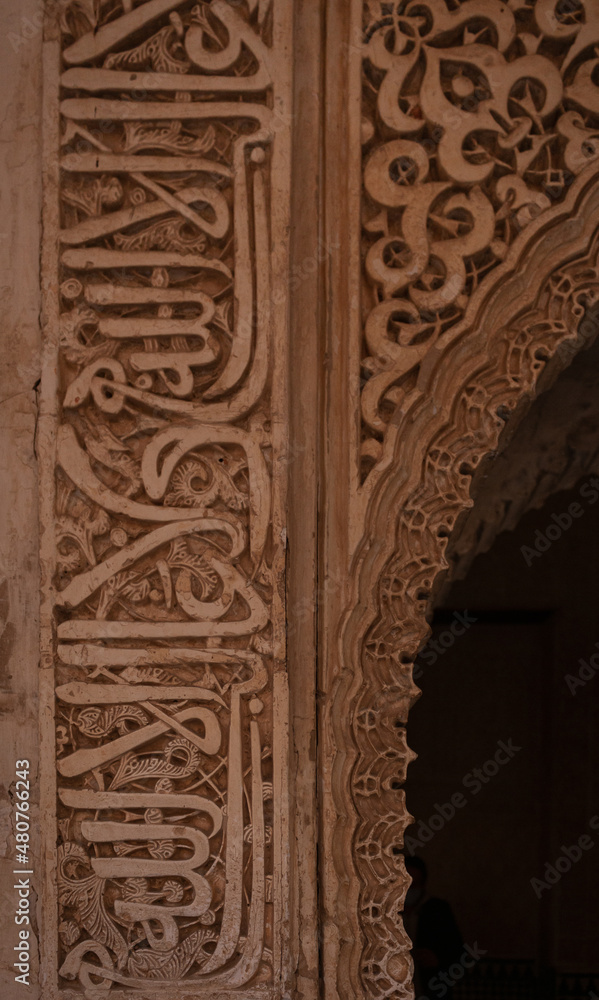 Vertical picture of arabic writing in a wall on the Alhambra, Granada, Spain. Phrases and poems 
sculptured on the wall.