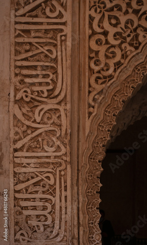 Vertical picture of arabic writing in a wall on the Alhambra, Granada, Spain. Phrases and poems 
sculptured on the wall.