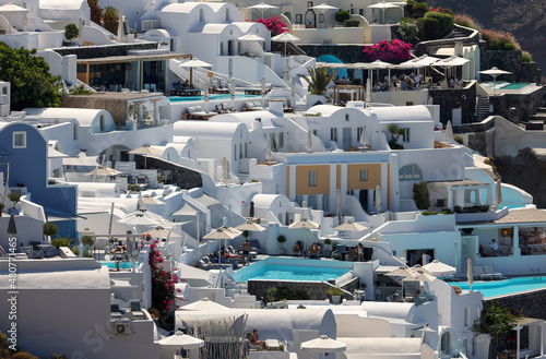 Whitewashed houses with terraces and pools and a beautiful view in Oia on Santorini island, Greece