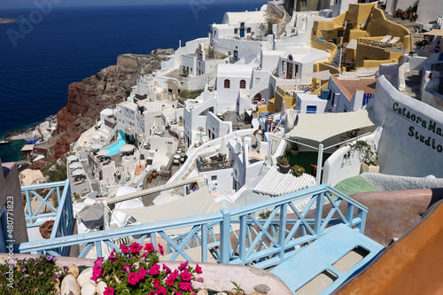 Whitewashed houses with terraces and pools and a beautiful view in Oia on Santorini island, Greece