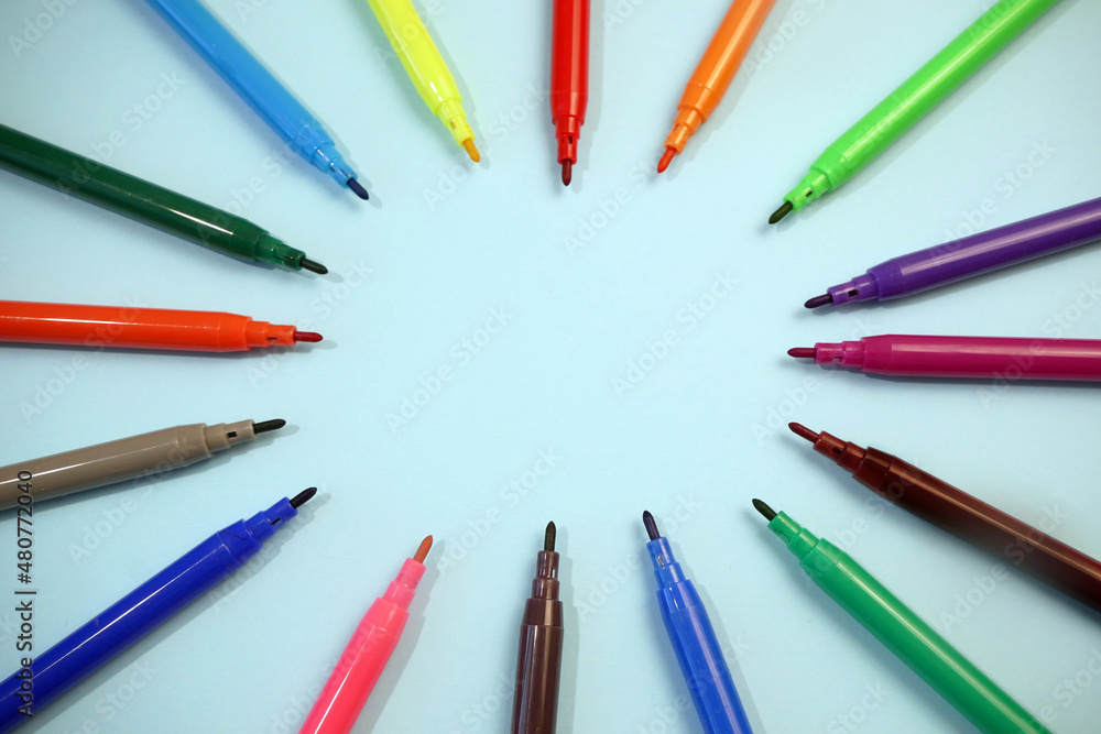 Naklejka premium many colorful markers facing the center on blue, good template for your creative idea, copy space