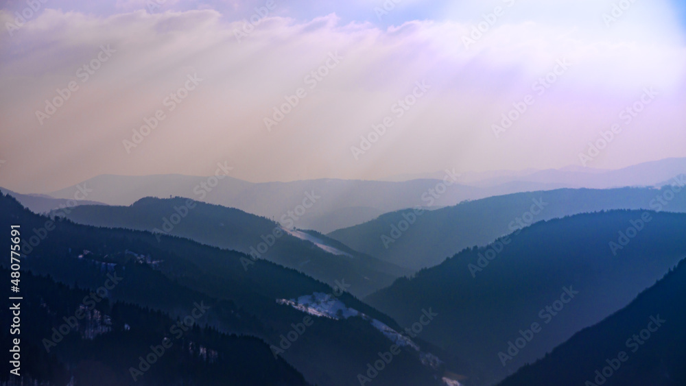 View over hills of the Black Forest caught in the haze against the sun.