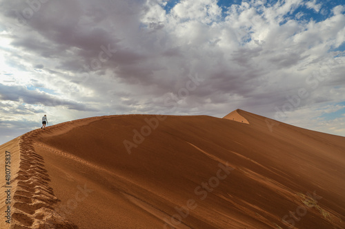 Lone hiker ascending Big Daddy dune in Namibia