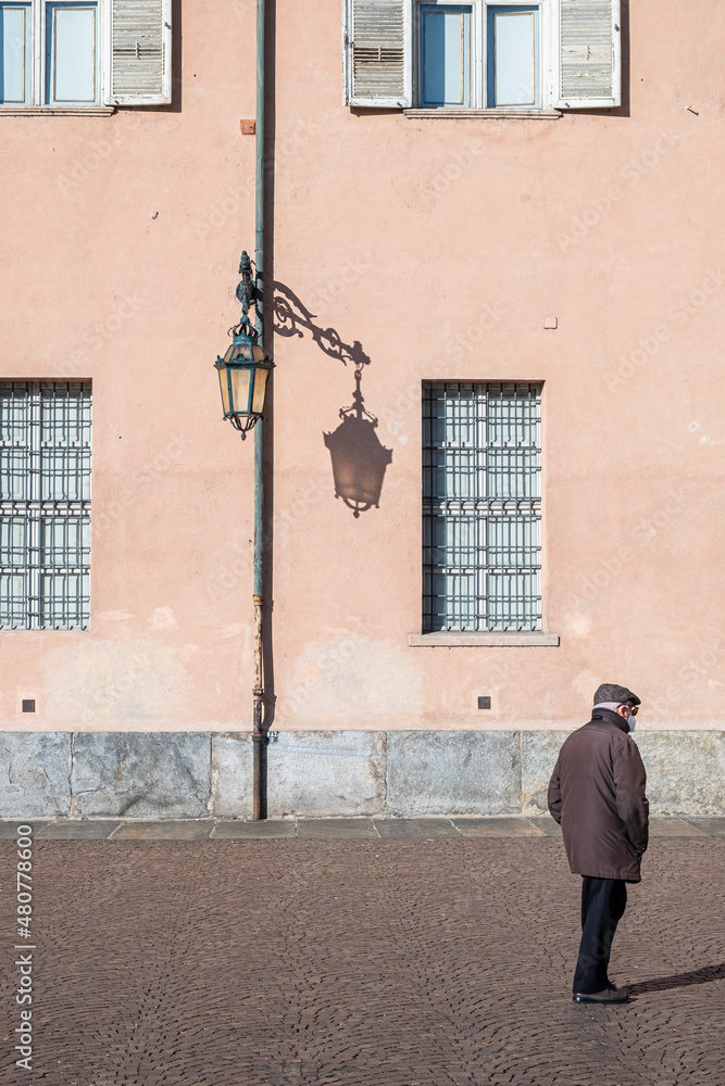old italian man walking alone in center of Turin
