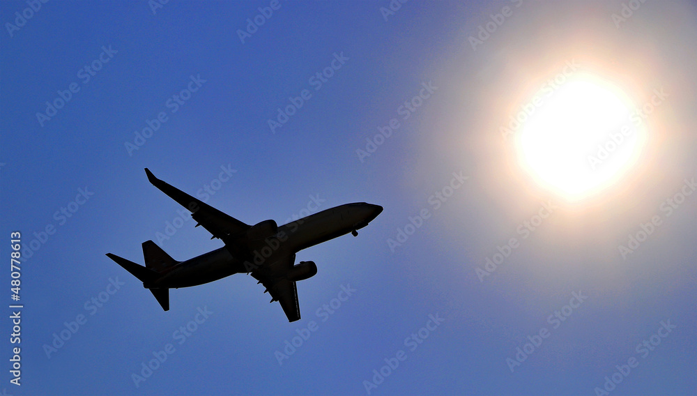 Jet airliner silhouetted against the sun
