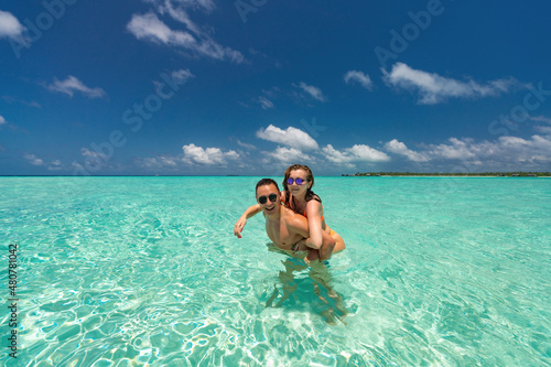 Young happy couple on tropical beach at summer vacation. © gawriloff