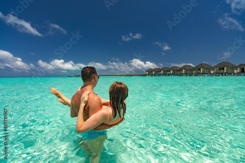 Young happy couple on tropical beach at summer vacation.