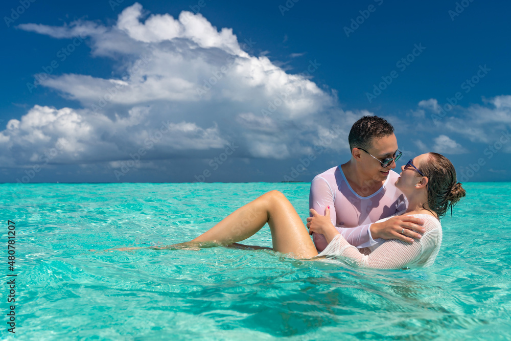 Young happy couple on tropical beach at summer vacation.
