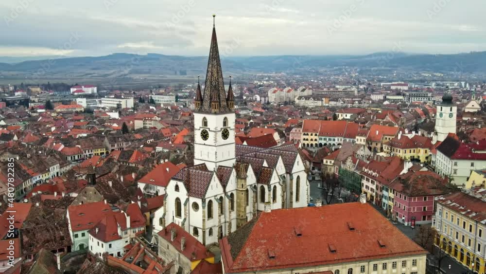 Aerial drone view of the Sibiu Lutheran Cathedral in Romania. Street with bare trees, multiple buildings, cityscape Aerial drone view of the Sibiu Lutheran Cathedral in Romania. Street with bare trees, multiple buildings, cityscape