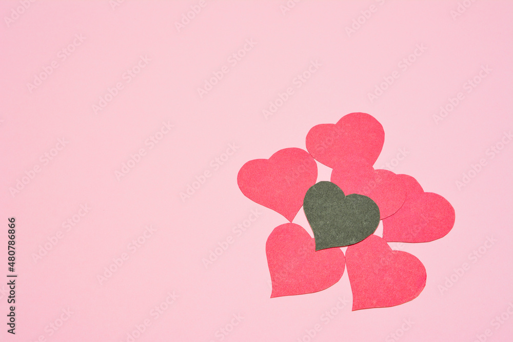 red and black paper hearts on pink background, place for text