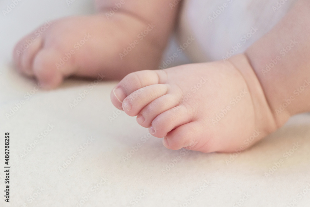 close up of small baby foot on white blanket close up of small baby foot on white blanket