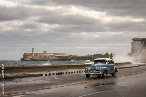 Old car on Malecon street of Havana with storm clouds in background. Cuba © danmir12