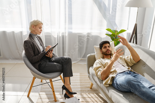 Female psychologist working with man on couch photo