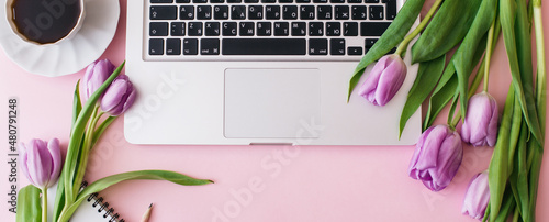Banner made Workspace with laptop, tulip flowers, cup of coffee on pink background. Home office desk. Flat lay, top view, copy space for text. Spring concept.