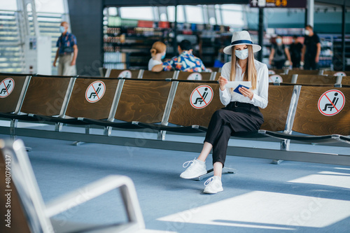 Woman wearing a mask for prevent virus with baggage in international airport. Protection against Coronavirus and gripp. © GRAFStock