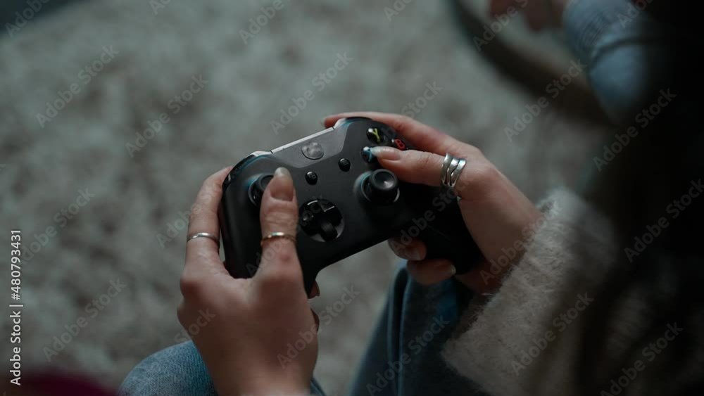 Close-up shooting of the gamepad. A Young Girl Playing a Video Game at Home Close-up shooting of the gamepad. A Young Girl Playing a Video Game at Home