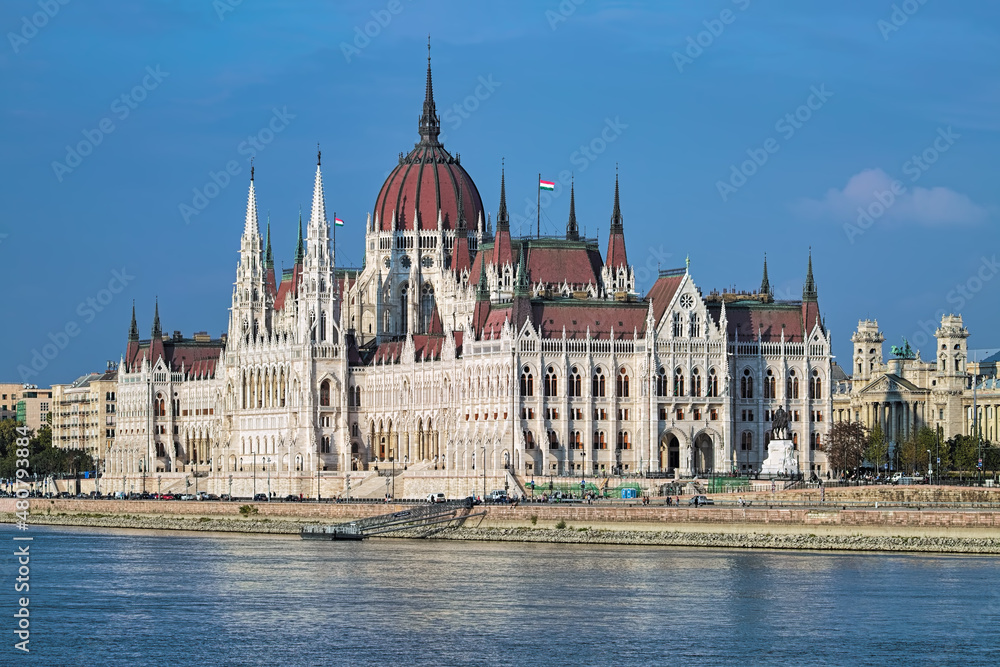 Budapest, Hungary. The Hungarian Parliament Building on the bank of the Danube, and fragment of the building of Ethnographic Museum, former Royal Palace of Justice.