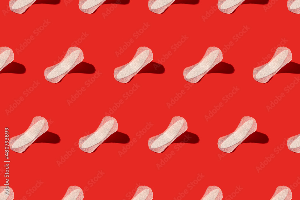 White menstrual pads on a red background. Seamless repeating pattern. White menstrual pads on a red background. Seamless repeating pattern.