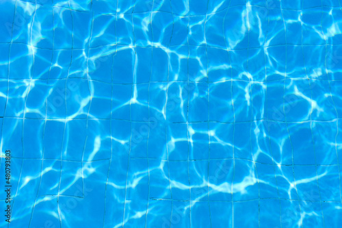 Water footprints in the pool against the background of blue tiles.Water texture