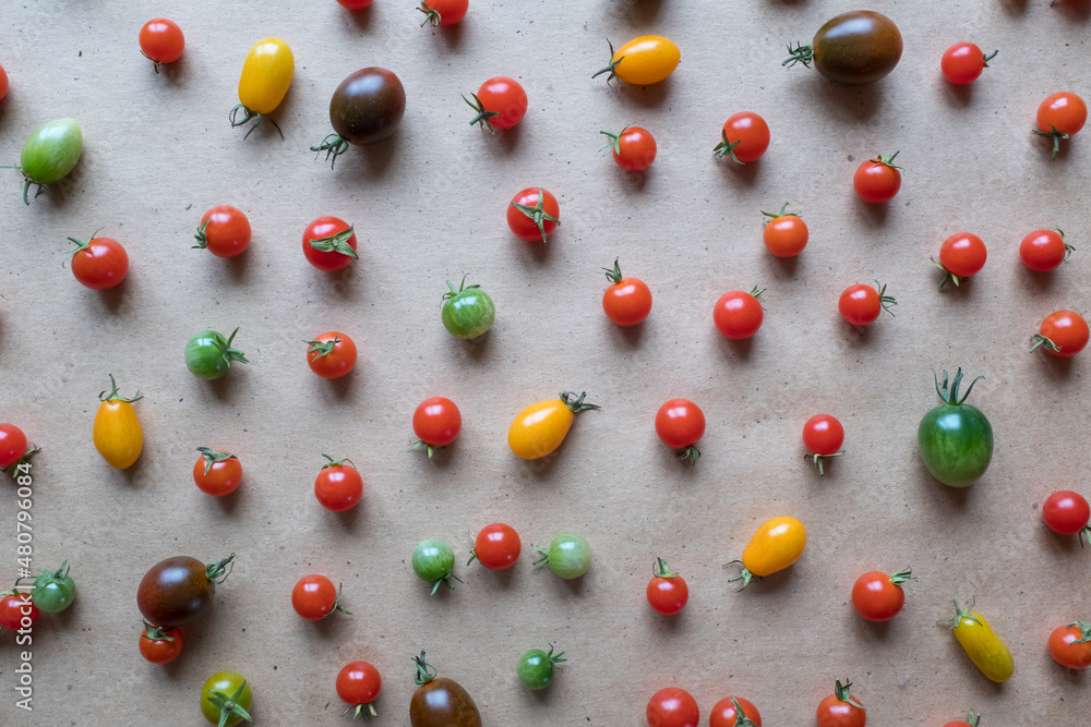 Colorful cherry tomatoes are scattered on the table, upper view. Still life of cherry tomatoes for publication, poster, screensaver, wallpaper, postcard, banner, cover, post. Healthy diet Colorful cherry tomatoes are scattered on the table, upper view. Still life of cherry tomatoes for publication, poster, screensaver, wallpaper, postcard, banner, cover, post. Healthy diet