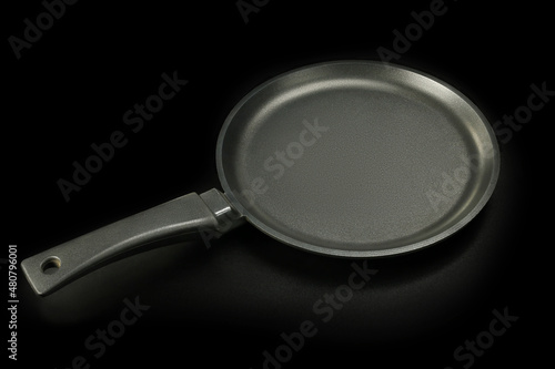 New clean frying pan, on black background 