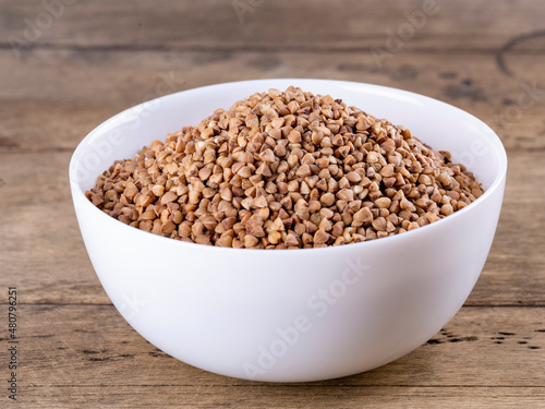 buckwheat in a white plate on a wooden background