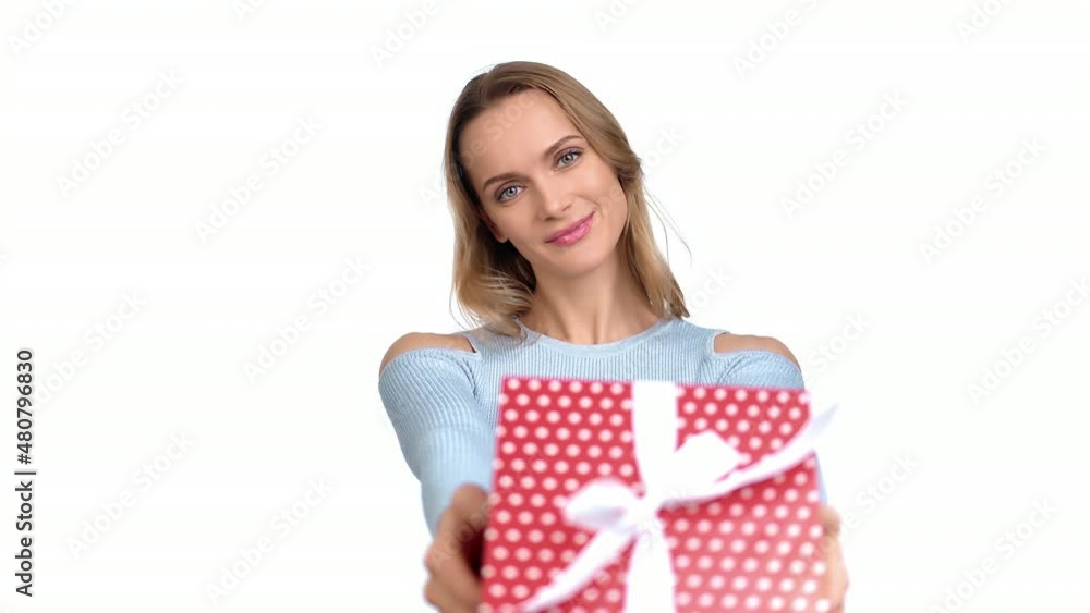 Portrait blonde woman giving red wrapped festive gift box with bow ribbon posing isolated on white Portrait blonde woman giving red wrapped festive gift box with bow ribbon posing isolated on white