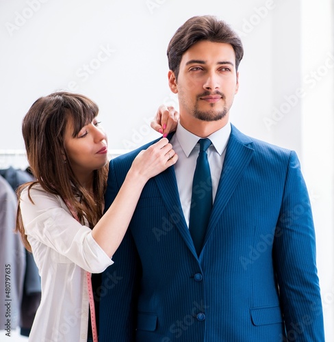 Professional tailor taking measurements for formal suit