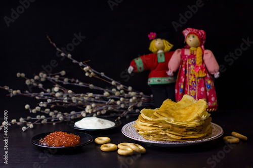 Background with pancakes, textile dolls, sushki, and pussy-willow for Maslenitsa festival.