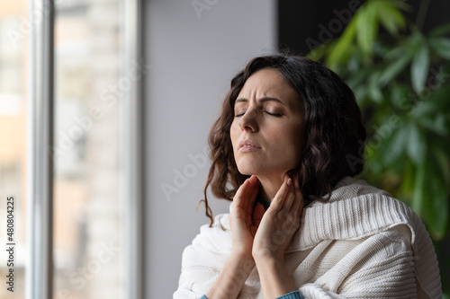 Sick woman suffer from sore throat touch enlarged lymph nodes staying home on sick leave. Unhappy young female with coronavirus disease, angina or pharyngitis illness symptoms. Girl feeling discomfort